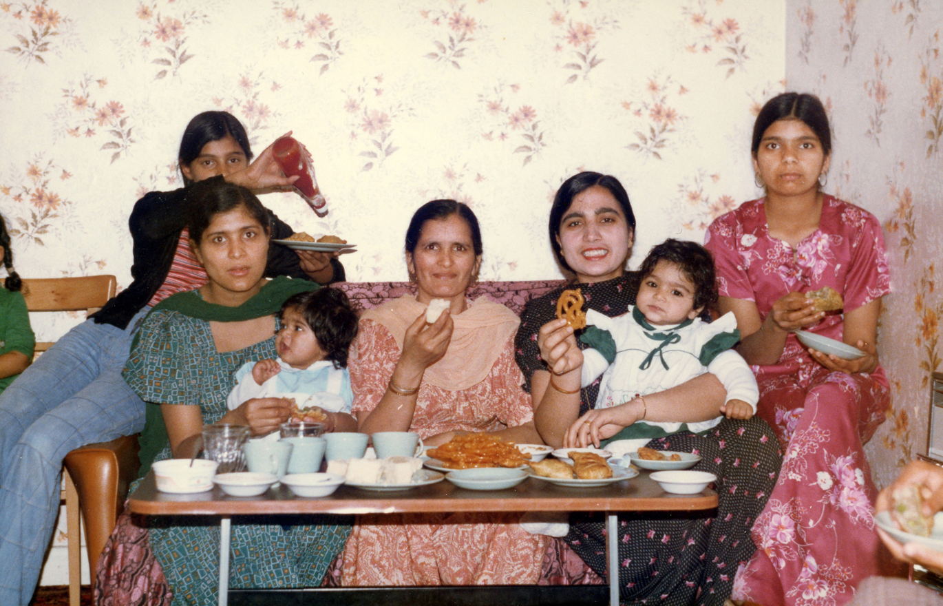 A family celebrate a birthday at home with a Punjabi meal, (Wolverhampton, 1979). Image courtesy of Black Country Visual Arts CIC